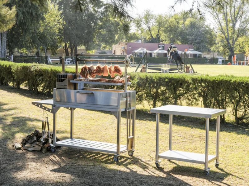 Stainless Steel Table in a field next to a Santa Maria Grill