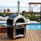 PINNACOLO | IBRIDO (HYBRID) Gas/Wood Pizza Oven With Accessories - PPO103 beside a pool 